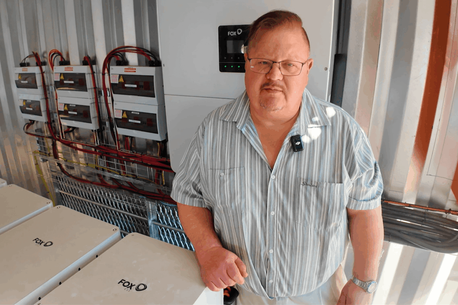 Installer standing next to a 125kW Fox ESS inverter used for industrial grade solar storage in South Africa.